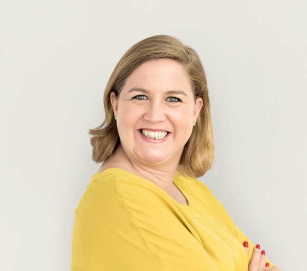Mulher adulta sorrindo, transmitindo confiança e satisfação com o tratamento médico.
